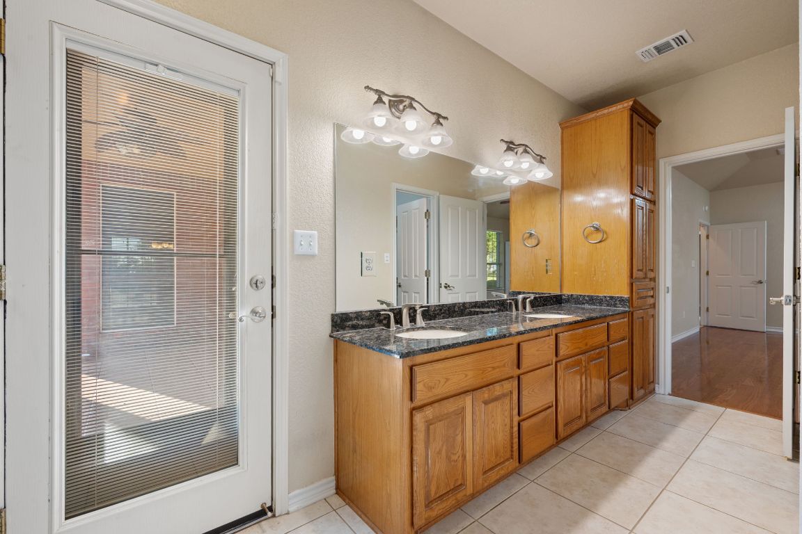 686 Benchmark Trail Belton, TX 76513 - Photo 16 of 38 a bathroom with a granite countertop sink a mirror and a shower