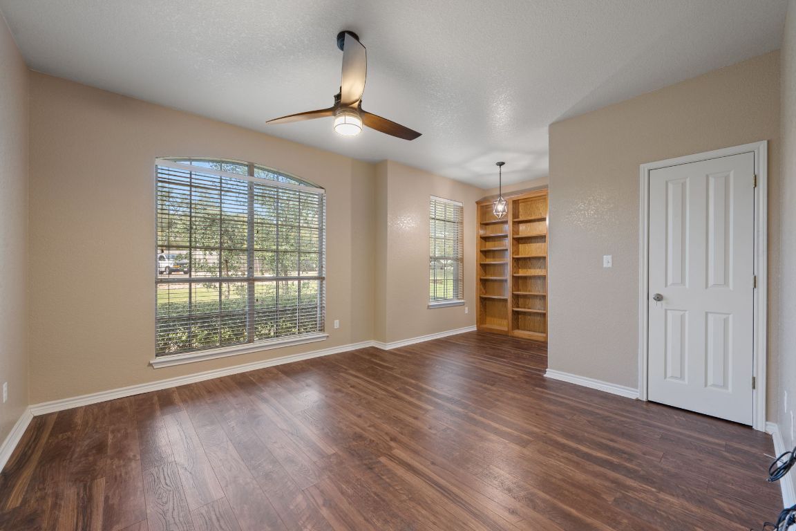 686 Benchmark Trail Belton, TX 76513 - Photo 17 of 38 an empty room with wooden floor chandelier and windows