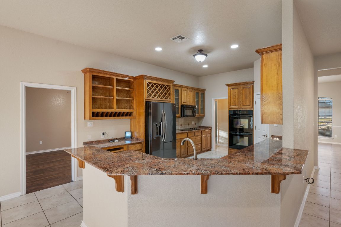 686 Benchmark Trail Belton, TX 76513 - Photo 6 of 38 a kitchen with stainless steel appliances granite countertop a sink and a refrigerator