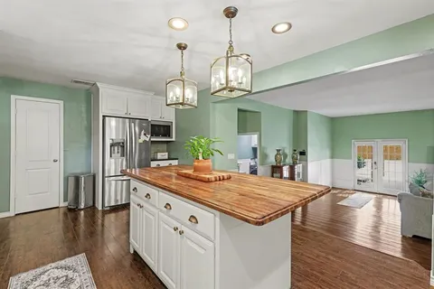 a large kitchen with kitchen island stainless steel appliances a table and chairs