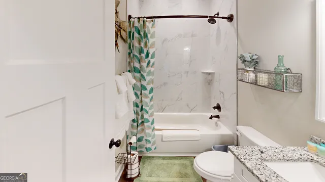 a bathroom with a bathtub shower sink and toilet