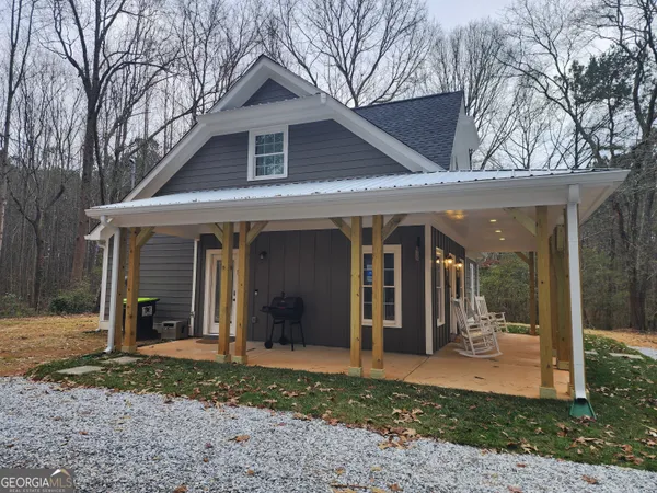 a front view of a house with a yard and seating space