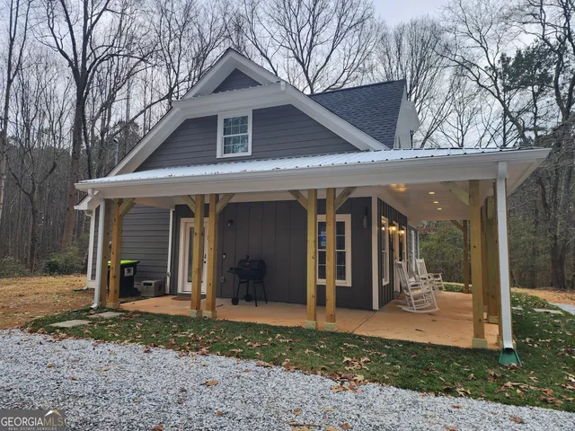 a front view of a house with a yard and seating space