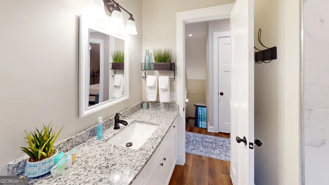 a bathroom with a granite countertop sink a mirror and shower