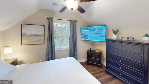 a bedroom with a bed and wooden floor