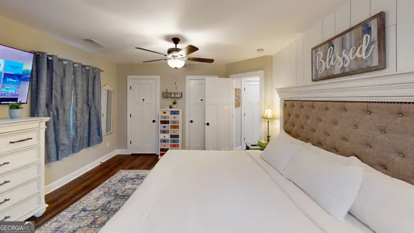 a bedroom with a large bed and a chandelier