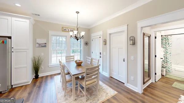 a dining room with furniture a chandelier and wooden floor