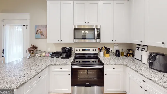 a kitchen with granite countertop a stove sink and cabinets