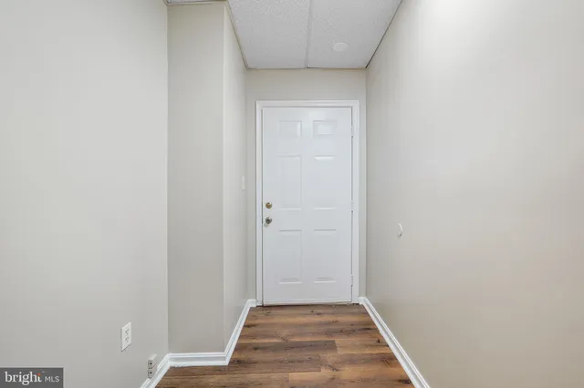 a view of a hallway with wooden floor and entryway