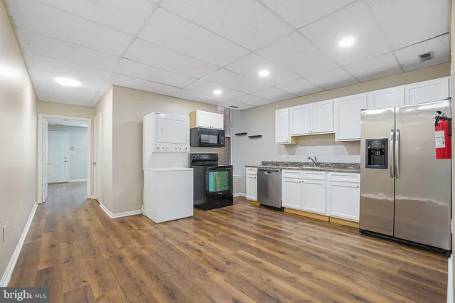 a kitchen with stainless steel appliances granite countertop a refrigerator and a stove top oven