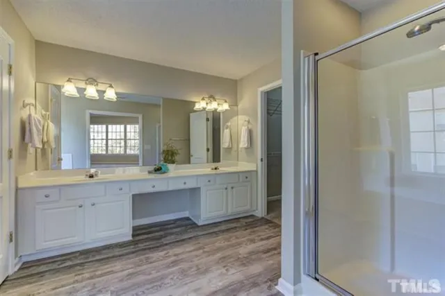 a large bathroom with a large mirror vanity and shower