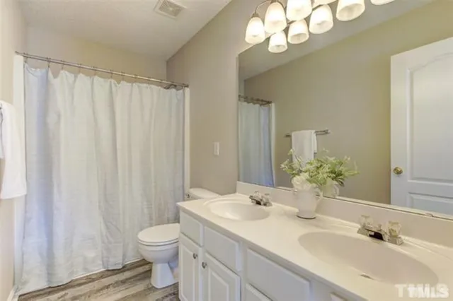a bathroom with a granite countertop sink a toilet and a mirror