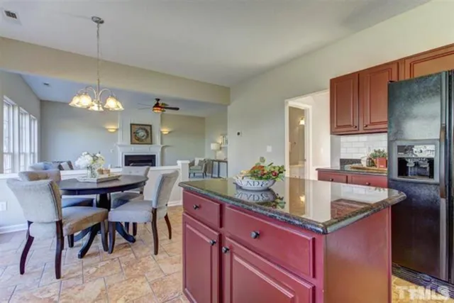 a dining hall with granite countertop a sink dishwasher a dining table and chairs with wooden floor