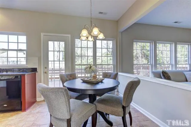 a dining room with furniture a chandelier and wooden floor
