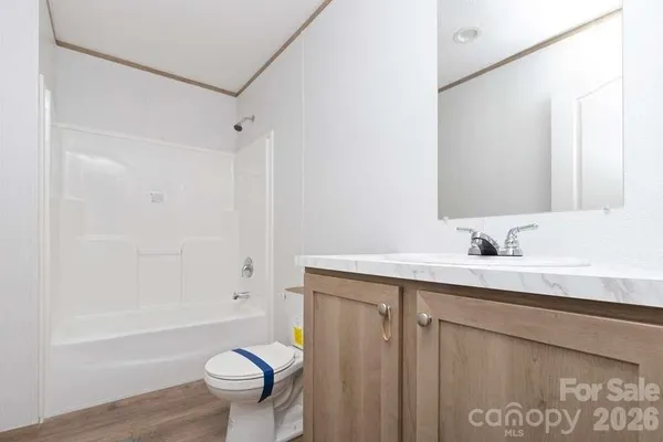 a bathroom with a granite countertop sink a toilet and shower