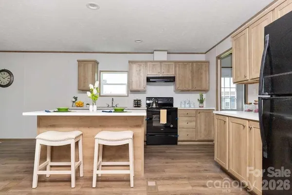 a kitchen with refrigerator cabinets and wooden floor
