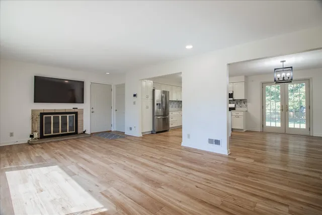 an empty room with wooden floor and a flat screen tv