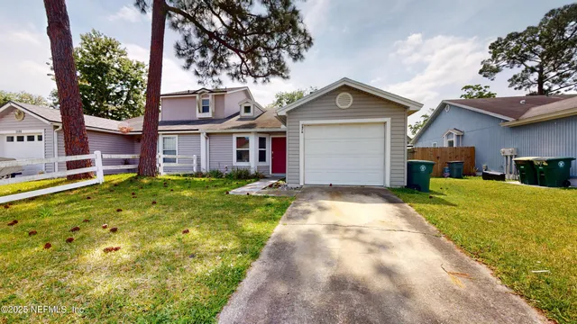 a front view of a house with a yard and trees