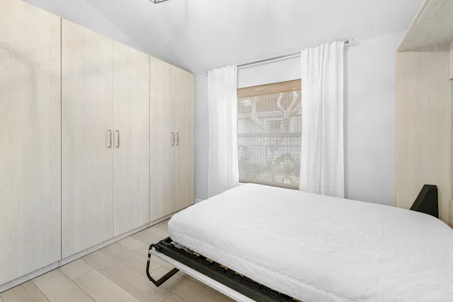 a front view of a house with a garden and trees