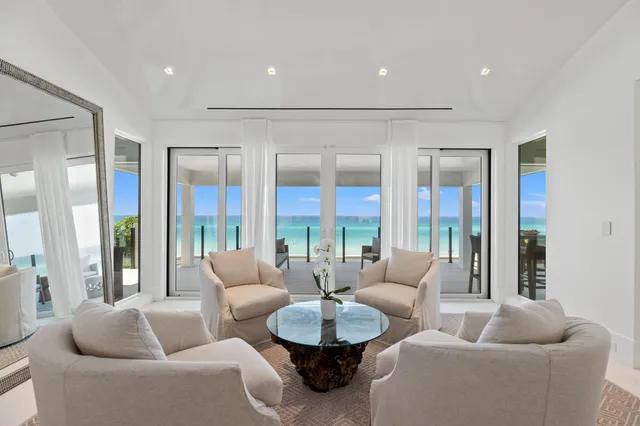 a large white bed in a bedroom next to a window