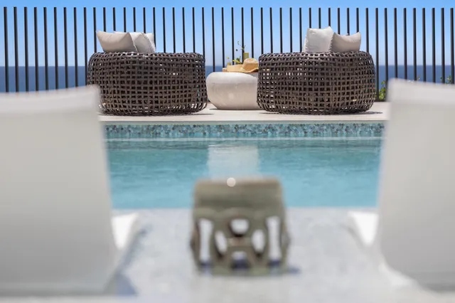 a living room with furniture kitchen view and a chandelier