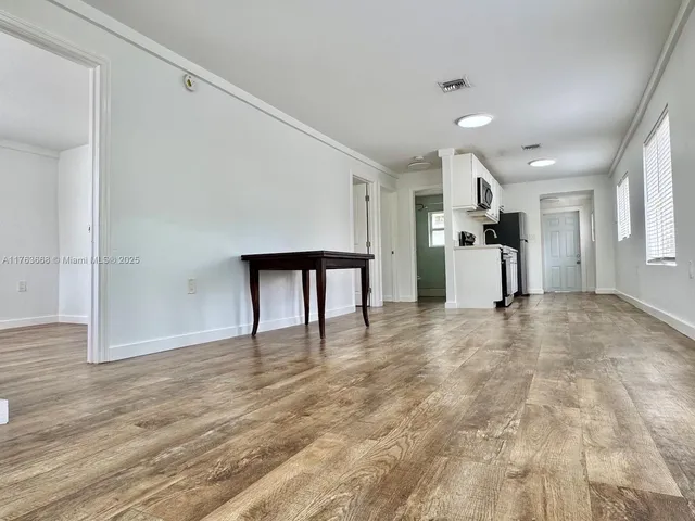 a view of empty room with wooden floor