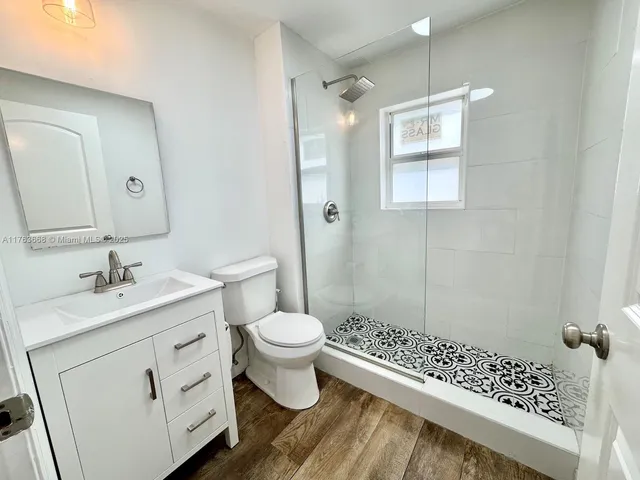 a bathroom with a sink toilet a mirror and shower