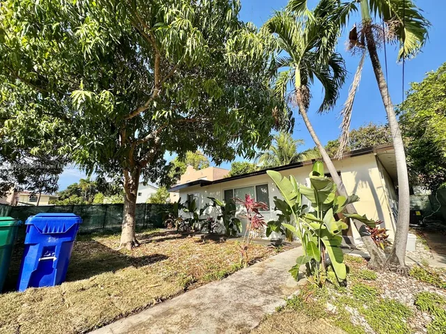 a front view of a house with a tree