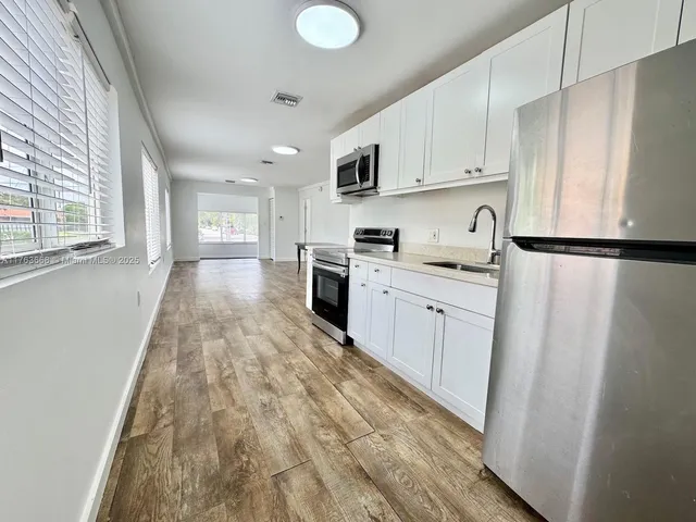 a kitchen with white cabinets and white appliances