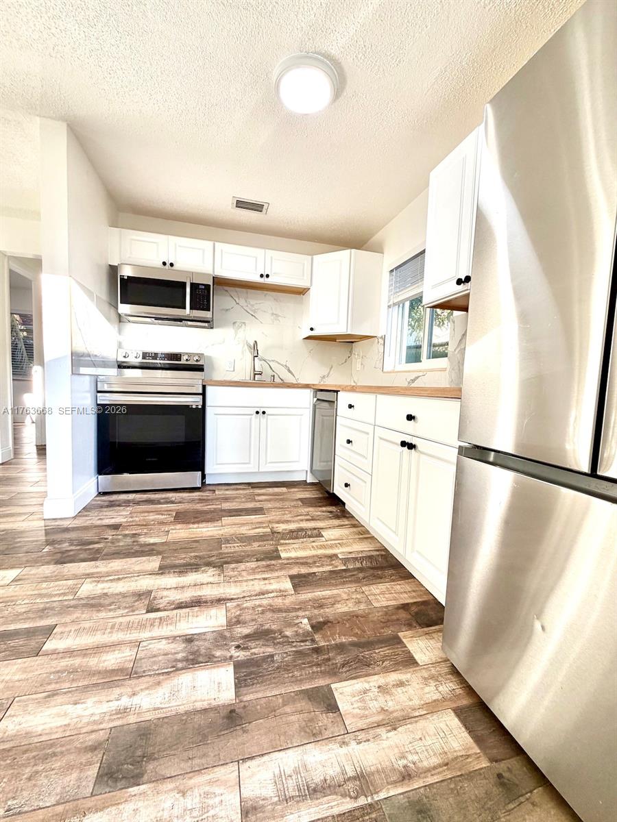 929 Southwest 12th Avenue Miami, FL 33130 - Photo 7 of 38 a kitchen with stainless steel appliances granite countertop a refrigerator a stove a sink and a microwave