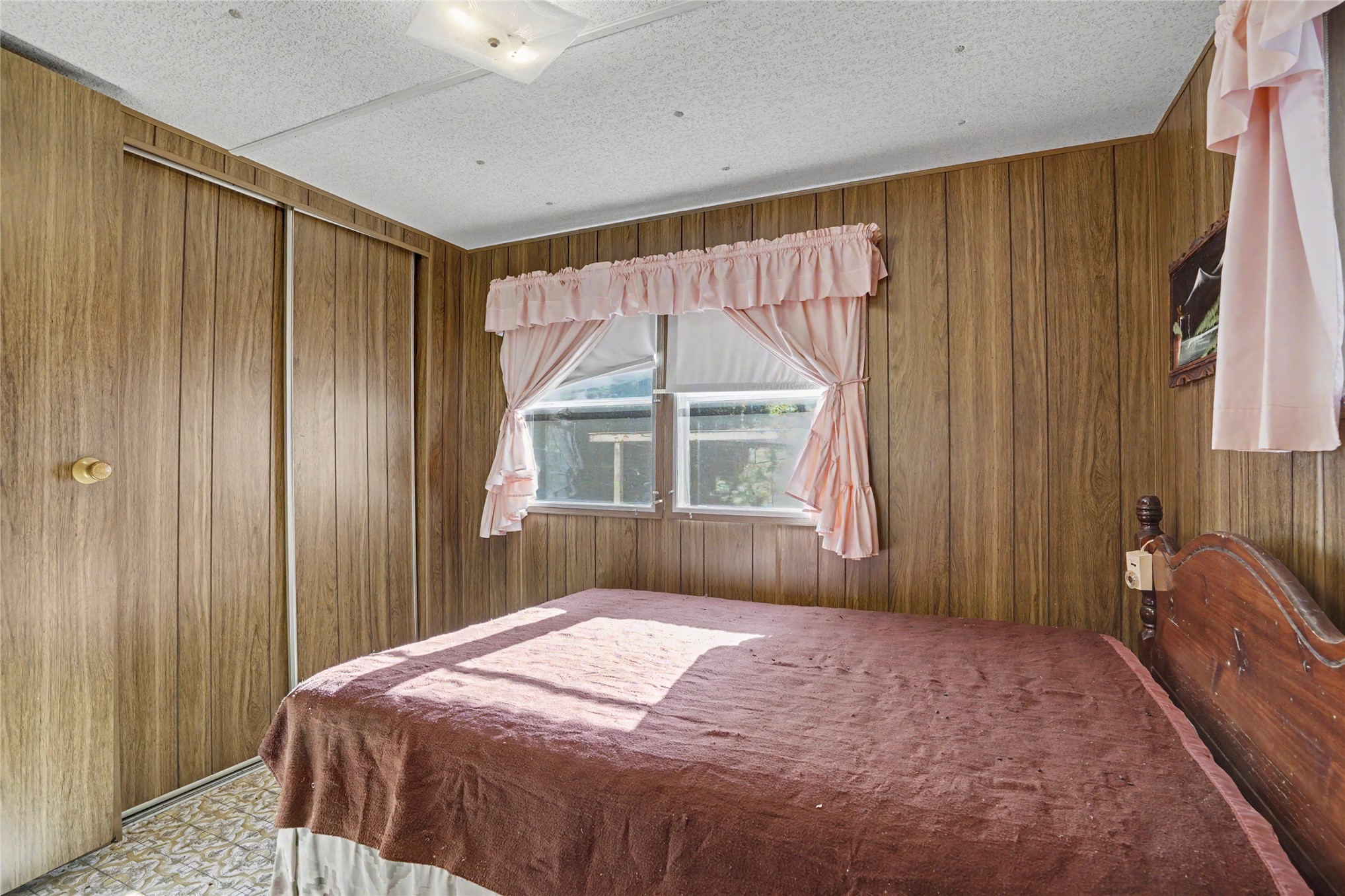 46420 South 590 Road Jay, OK 74346 - Photo 37 of 63 Wood-finish paneling, window with natural light, textured ceiling, and built-in sliding closet doors