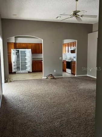 an empty room with windows and fireplace