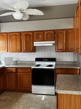 a kitchen with a sink a stove and cabinets