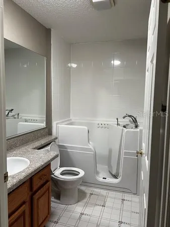 a bathroom with a granite countertop toilet a sink and a mirror
