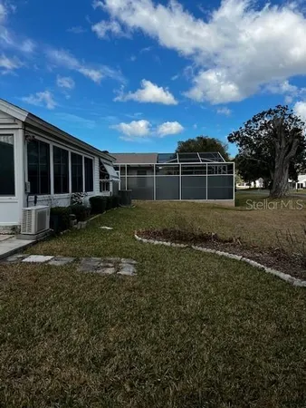 a view of a backyard with plants and large tree