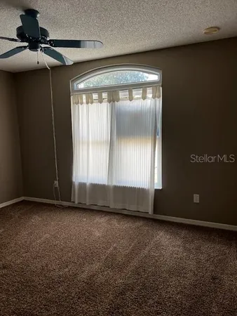 a view of room with a ceiling fan and window