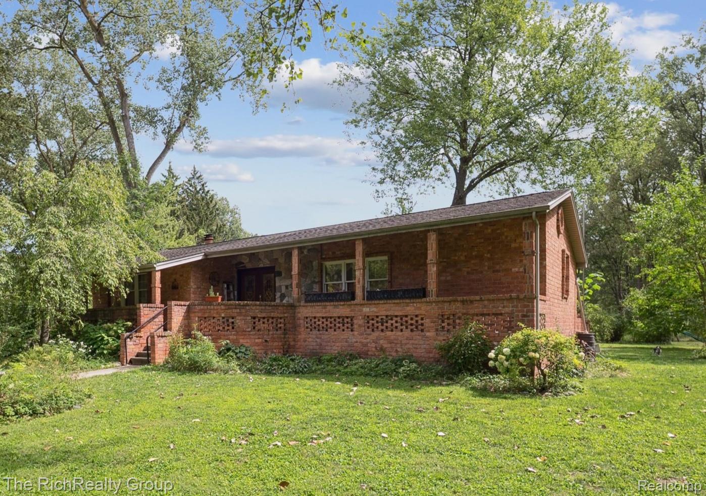 39635 Lotzford Road Canton, MI 48187 - Photo 2 of 39 Rear view of house featuring a porch, brick siding, a lawn, stairway, and a chimney
