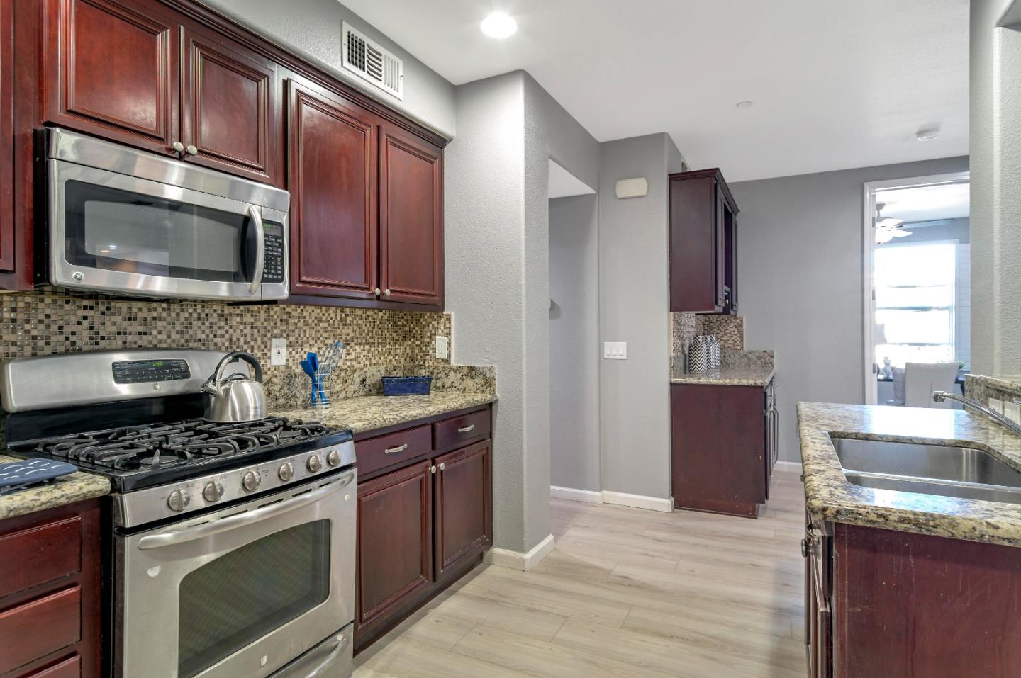 1814 Snell Place Milpitas, CA 95035 - Photo 14 of 49 a kitchen with stainless steel appliances granite countertop a stove microwave sink and refrigerator