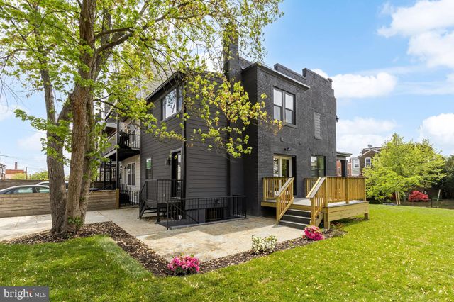 a view of backyard with a barn and a large tree