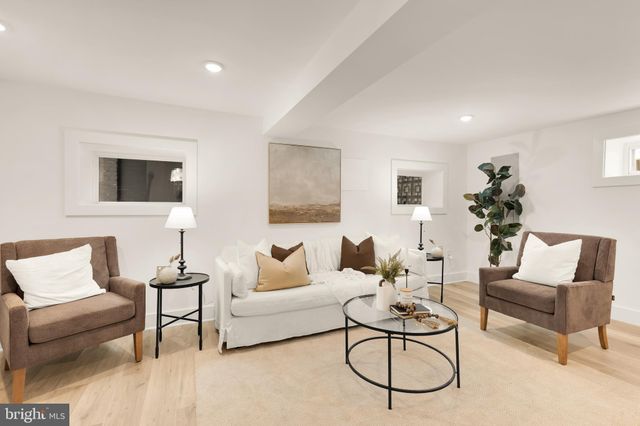 a living room with furniture a rug and a lamp