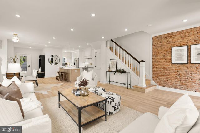 a living room with furniture kitchen view and a chandelier