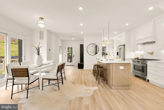 a living room with furniture kitchen view and a wooden floor