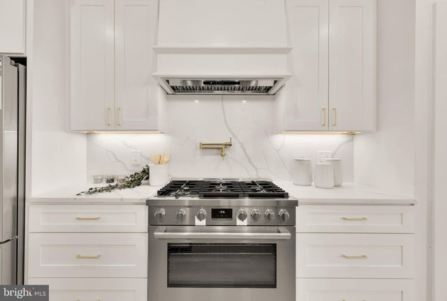 a stove top oven sitting inside of a kitchen