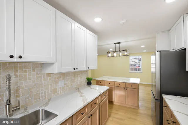 a kitchen with stainless steel appliances a refrigerator sink and cabinets