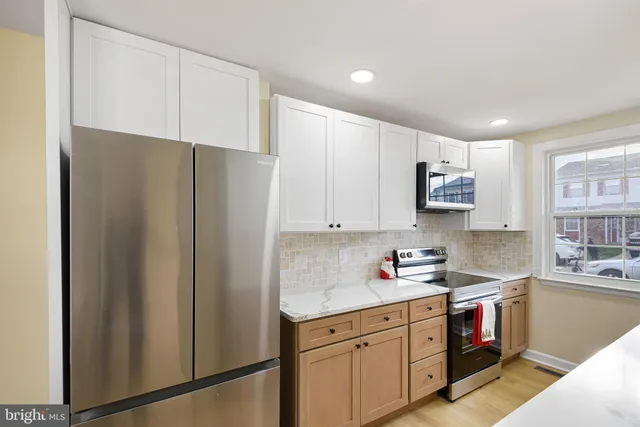 a view of a big room with wooden floor and windows