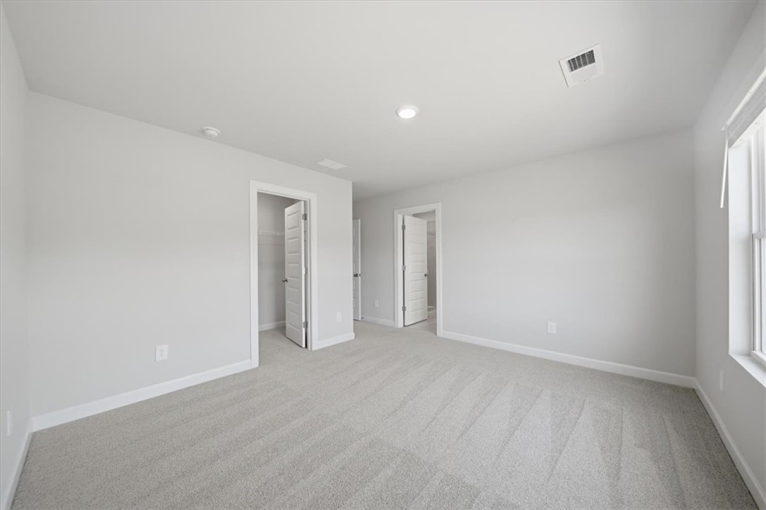 129 Kerwin Court Woodruff, SC 29388 - Photo 22 of 30 A spacious, naturally illuminated room featuring plush carpet and ample storage with multiple doorways.