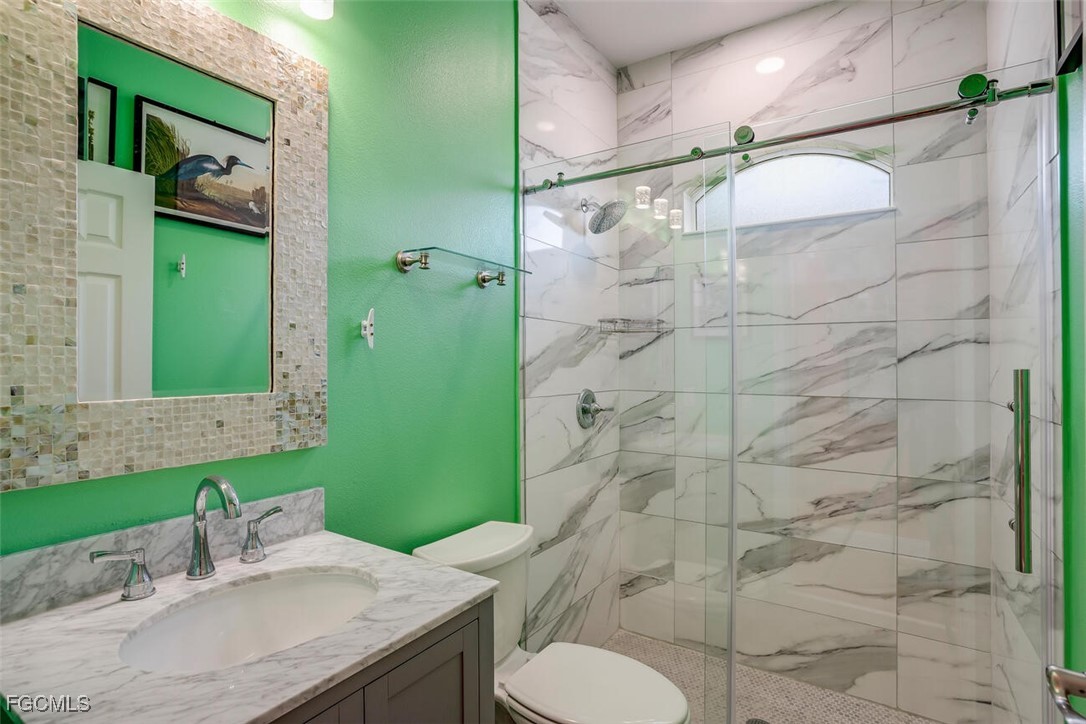 139 Crevalle Road Rotonda West, FL 33947 - Photo 17 of 24 a bathroom with a granite countertop sink toilet and shower