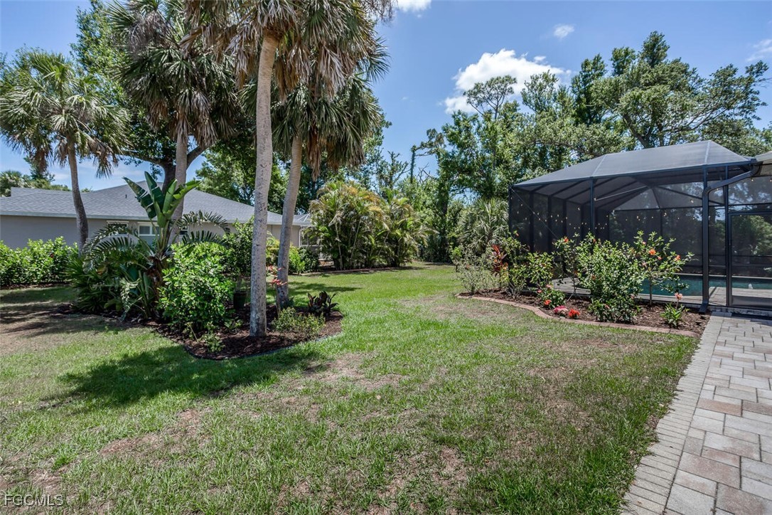 139 Crevalle Road Rotonda West, FL 33947 - Photo 24 of 24 a view of a backyard with potted plants and large trees