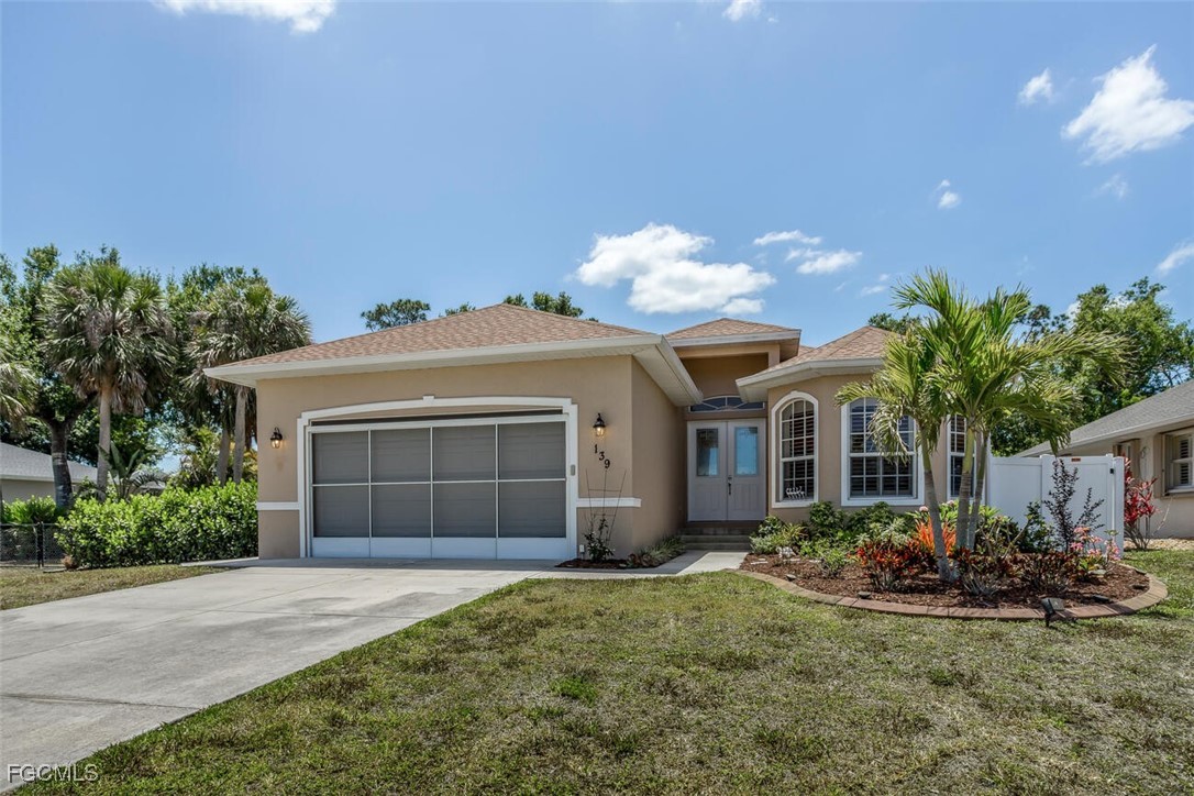 139 Crevalle Road Rotonda West, FL 33947 - Photo 3 of 24 a front view of a house with a garden and yard