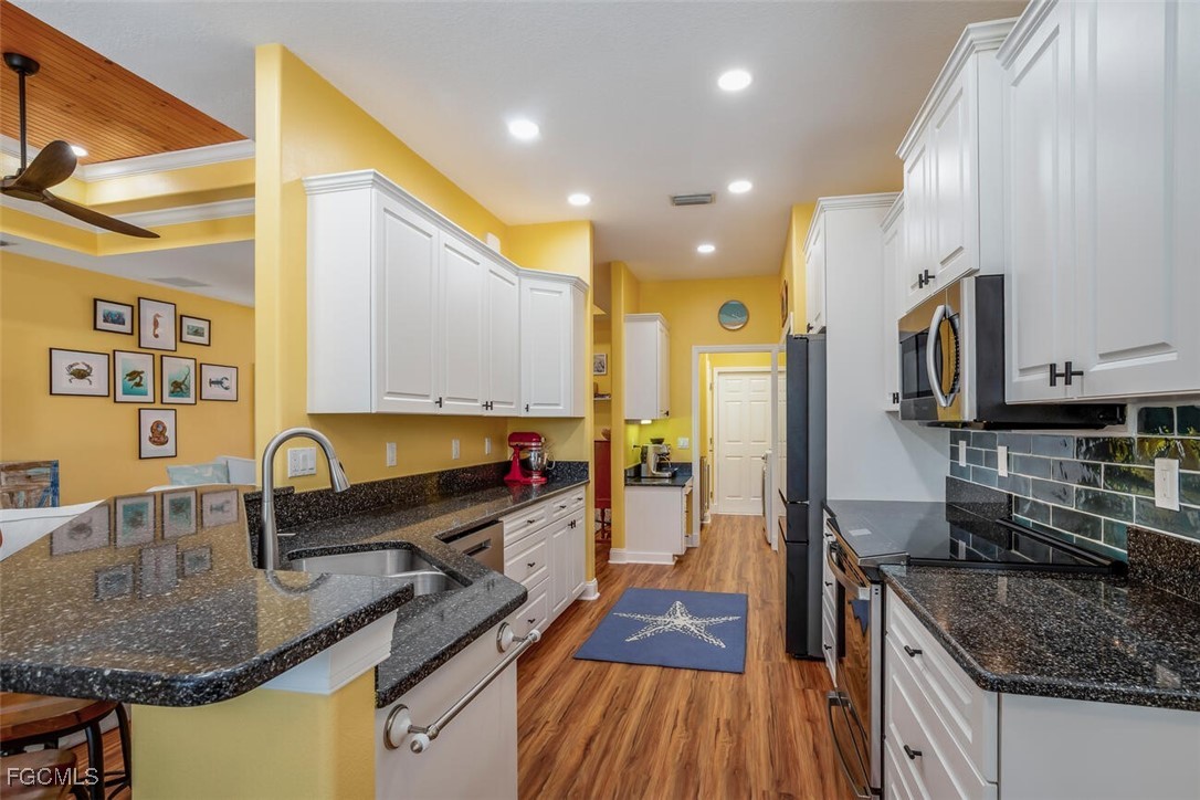 139 Crevalle Road Rotonda West, FL 33947 - Photo 7 of 24 a kitchen with stainless steel appliances granite countertop a sink stove and refrigerator